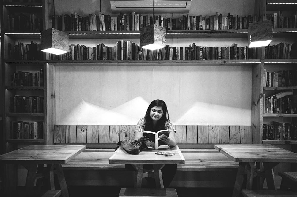 Jeune femme seule dans un café avec livres