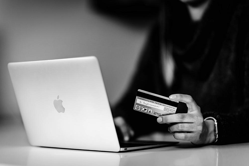 Main avec carte de crédit pour payer en ligne avec son laptop ordinateur portable